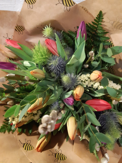 Sea Breeze - A bunch of mixed seasonal blooms, wrapped in kraft paper and tied with raffia.