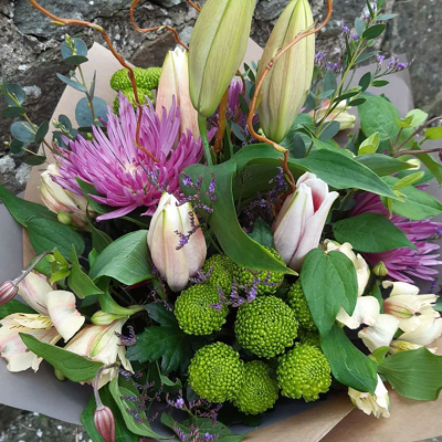 Petal Paradise - A lively bouquet featuring a bright mix of vibrant seasonal blooms. Complemented by lush green foliage and presented in a beautiful packaging, this arrangement is perfect for adding a pop of colour to any occasion