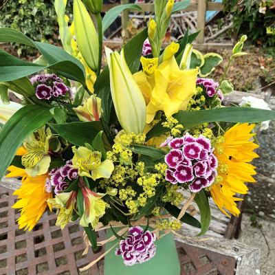 The Happy Vase - Happy Vase floral arrangement, made up of bright blooms and leaves.